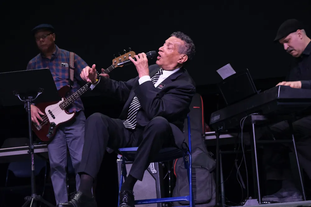 Tim Stevens singing between two male band musicians