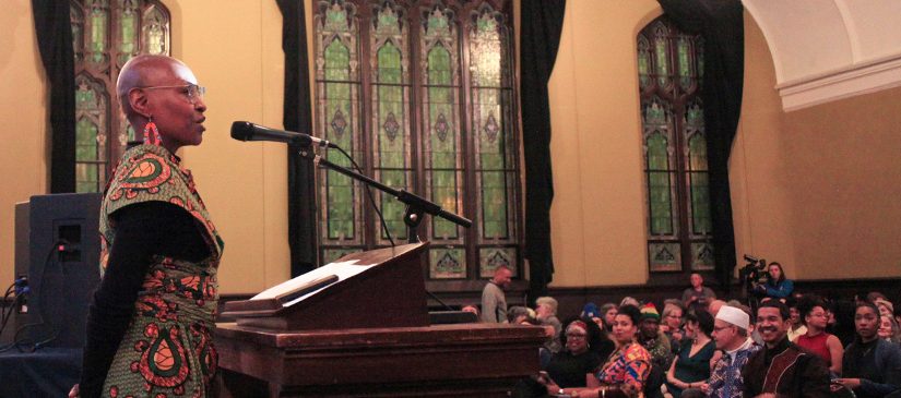 Image of previous event coordinator addressing room full of people.